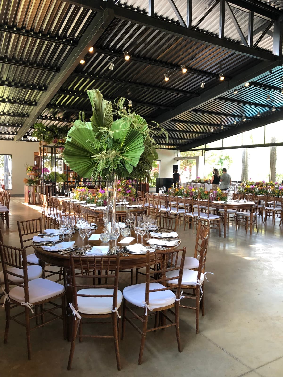 Salão de festas da Xakara montado para casamento, com mesas redondas e flores